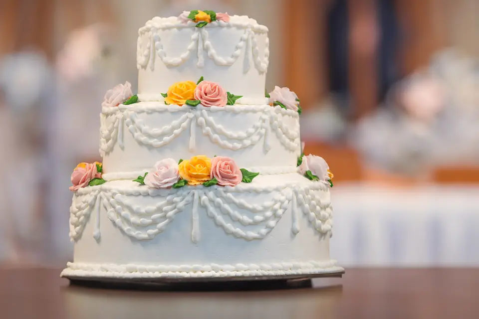 Round buttercream reception cake with piped borders and a smooth finish from Taylor's Bakery